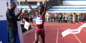 Irene Cheptai celebrating winning a past a race.