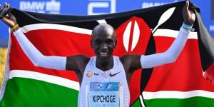 Marathon world record holder Eliud Kipchoge poses for a photo with the Kenyan flag after winning the 2022 Berlin Marathon on September 25 in Germany.