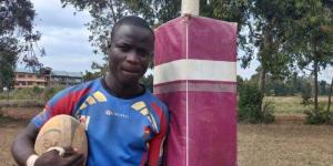 Emmanuel Olume posing with a rugby ball in 2022.