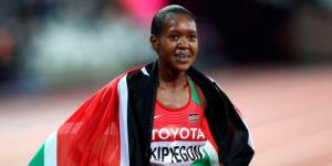 Faith Chepngetich Kipyegon poses for a photo with Kenyan flag.