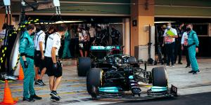 Hamilton driving his Mercedes Formula 1 car as he exits the pit zone before a race.