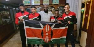 The Kenyan squash team poses for a photo with the countries flag.