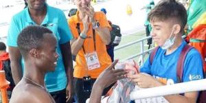 Felix Korir handing his Athletics Kenya jersey to a Colombian little boy at the 2022 Under 20 World Athletics Championship.