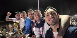Argentine footballers pose for a selfie after arriving in Buenos Aires with the FIFA World Cup trophy on December 20, 2022.