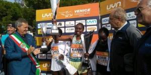 Kenyan runner Lucy Karimi (third from left) lifts her trophy after winning the 2022 Venice Marathon title on October 2022 in Italy.