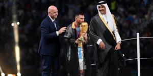 Argentine forward Lionel Messi (M) kisses the World Cup trophy as Emir of Qatar Tamim bin Hamad Al Thani (R) and FIFA President Gianni Infantino (L), look on 