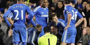 Ralph Rogers attending to Chelsea former Goalkeeper Petr Cech surrounded by other Chelsea players during an EPL match.