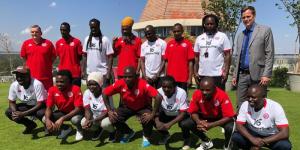Deputy German ambassador to Kenya Thomas Wimmer (donning a suit) poses for a photo with Kenyan coaches in Germany on January 31, 2023.