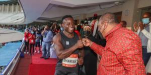 Ferdinand Omanyala (L) being congratulated by Kenya's ex-president Uhuru Kenyatta at Kasarani stadium on May 7, 2022.