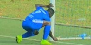 A player removing an object from the goal post in the Rwanda Premier League in 2015.