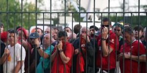 Liverpool fans covering their noses after French police fire teargas canisters at them at the State de France stadium on May 28, 2022.