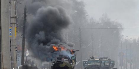 A Russian Armored personnel carrier (APC) burns next to an unidentified soldier's body during a fight with the Ukrainian armed forces in Kharkiv, Feb. 27, 2022.