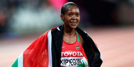 Faith Chepngetich Kipyegon poses for a photo with Kenyan flag.