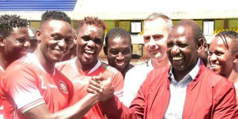 Harambee Stars players share a light moment with President William Ruto.