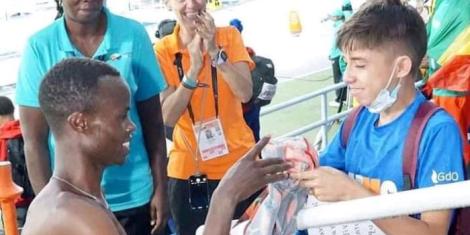 Felix Korir handing his Athletics Kenya jersey to a Colombian little boy at the 2022 Under 20 World Athletics Championship.