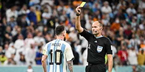 From left to right: Argentine footballer Lionel Messi stands as Spanish referee issues him a yellow card on December 9, during the 2022 Qatar World Cup.
