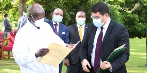 Ugandan President Yoweri Kaguta Museveni (L) looks at a document while a representative from Morocco watches on December 4, 2022 in Kampala.