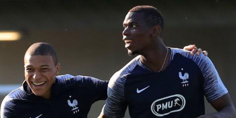 Kylian Mbappe (L) sharing a light moment with teammate Paul Pogba (R) during a past French national football team training session.