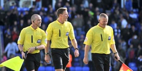 Referees on the football pitch during a match