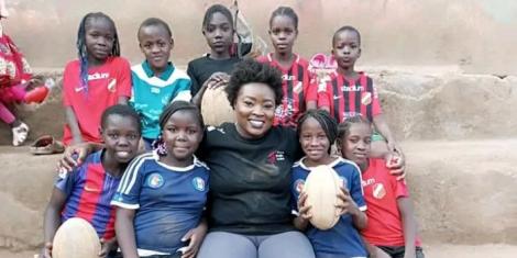 Mercy Migongo posing for a photo with some of the young girls who are part of the Kibera Golden Stars Rugby Program in Nairobi.