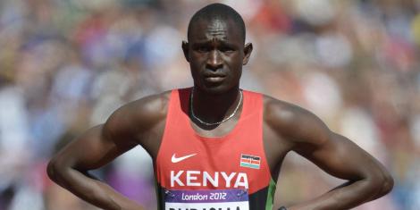 Retired Kenyan 800m Olympic champion David Rudisha stands akimbo on the running track.